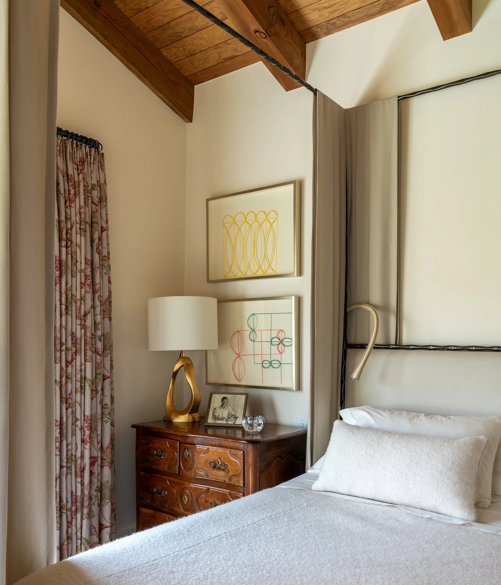 Bedroom nightstand chest styled with framed art beside the canopy bed — interior design photography Driggs Idaho, WTG Architects